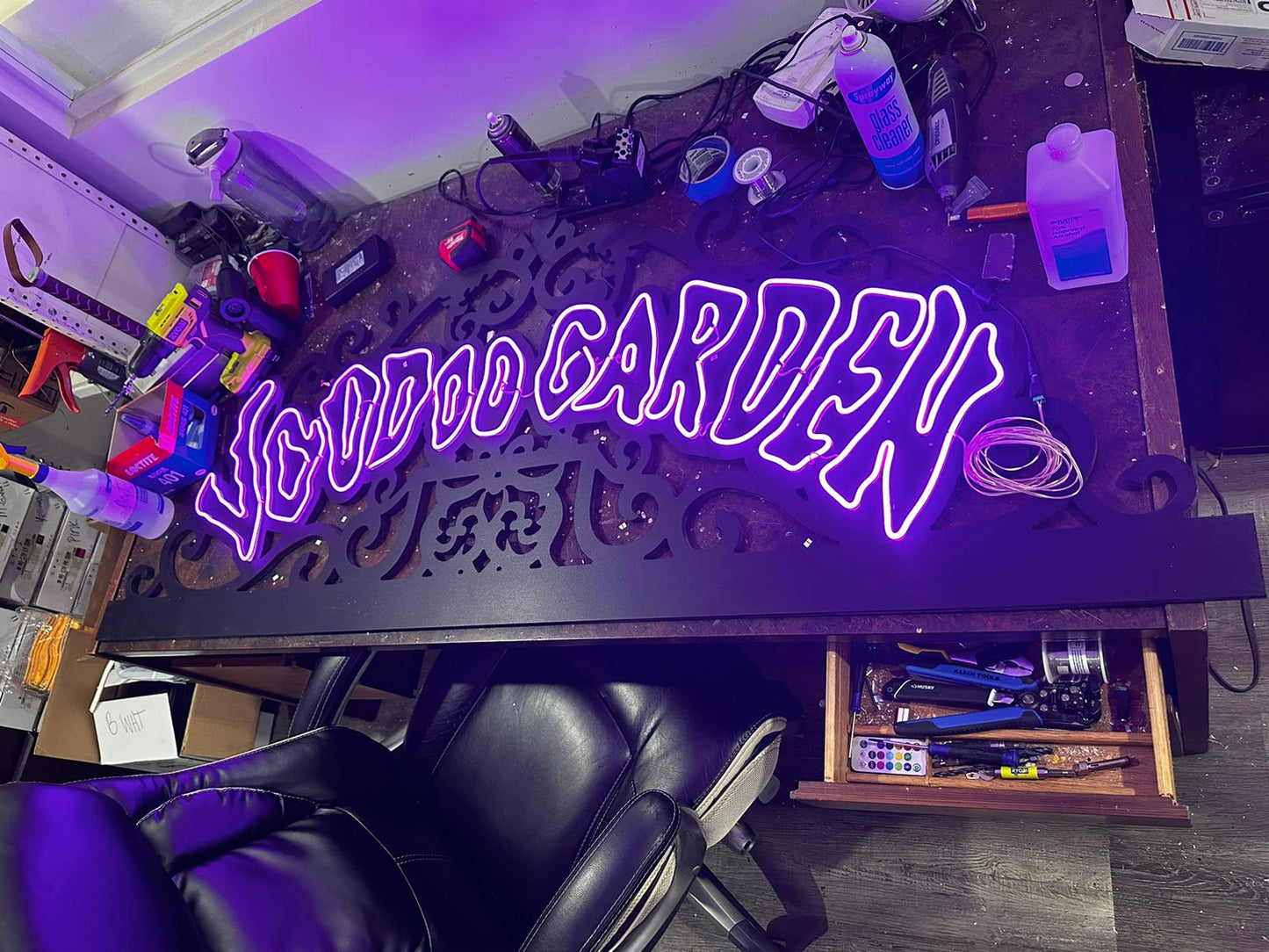 a purple neon sign sitting on top of a wooden table