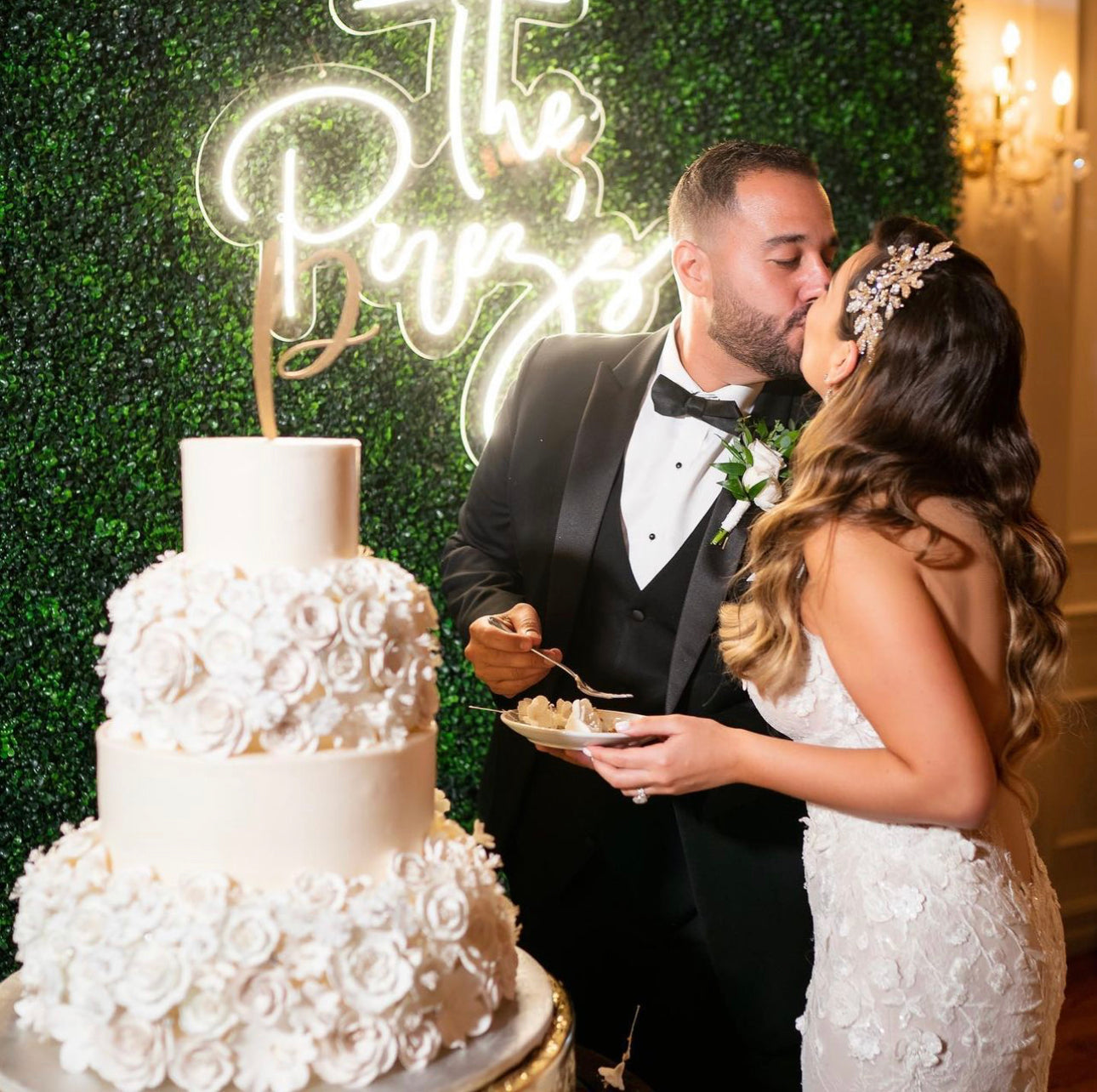 a bride and groom kissing in front of a wedding cake